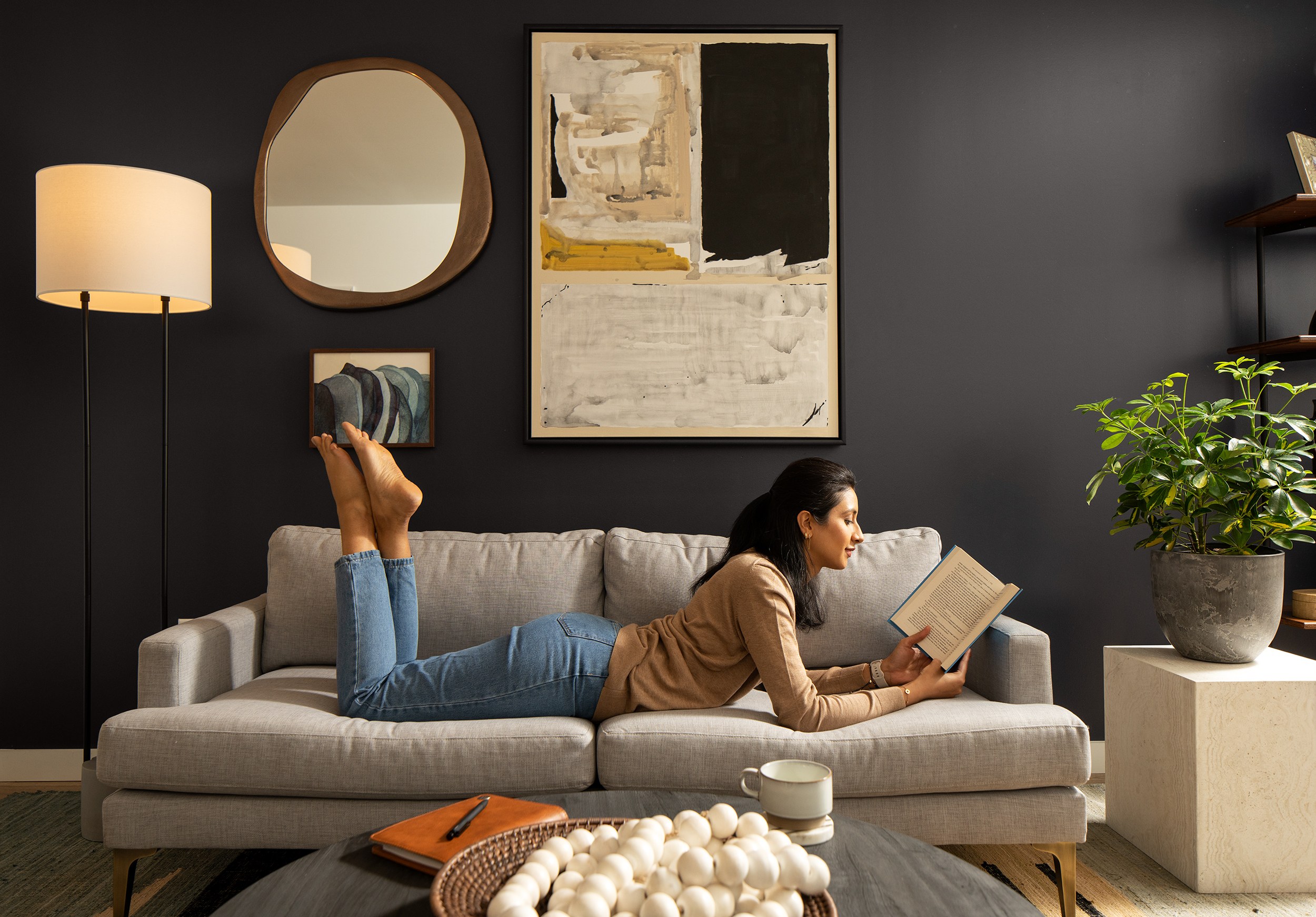 A woman on the couch & reading a book