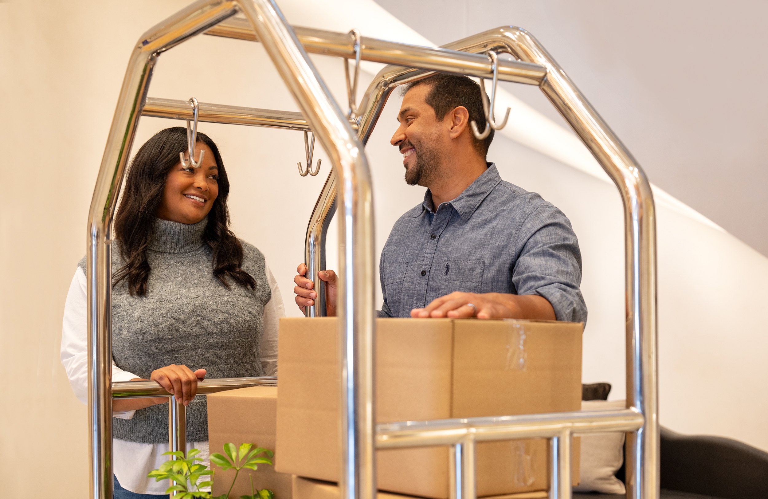 A man and woman actively moving boxes in a living room