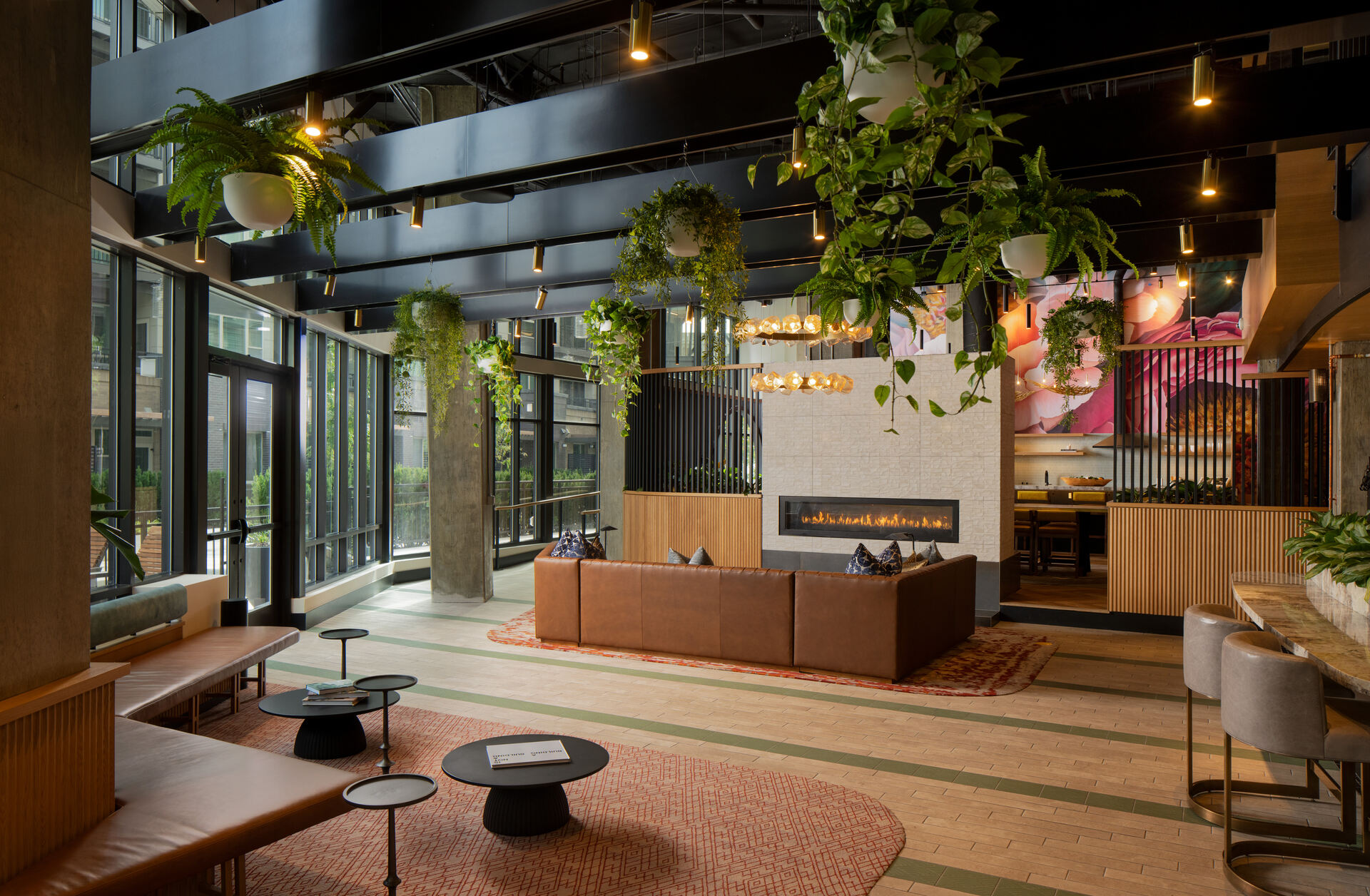 Lobby area in Atwell's luxury apartments in Silver Spring, MD showcasing multiple seating areas and greenery hanging from the roof
